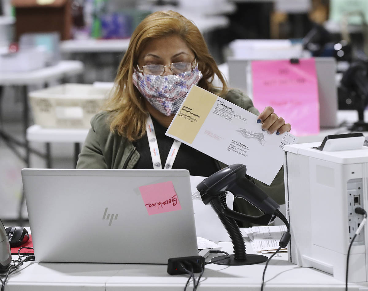 Election workers check-in, sort, and signature verify absentee ballots for the state's U.S. Sen ...