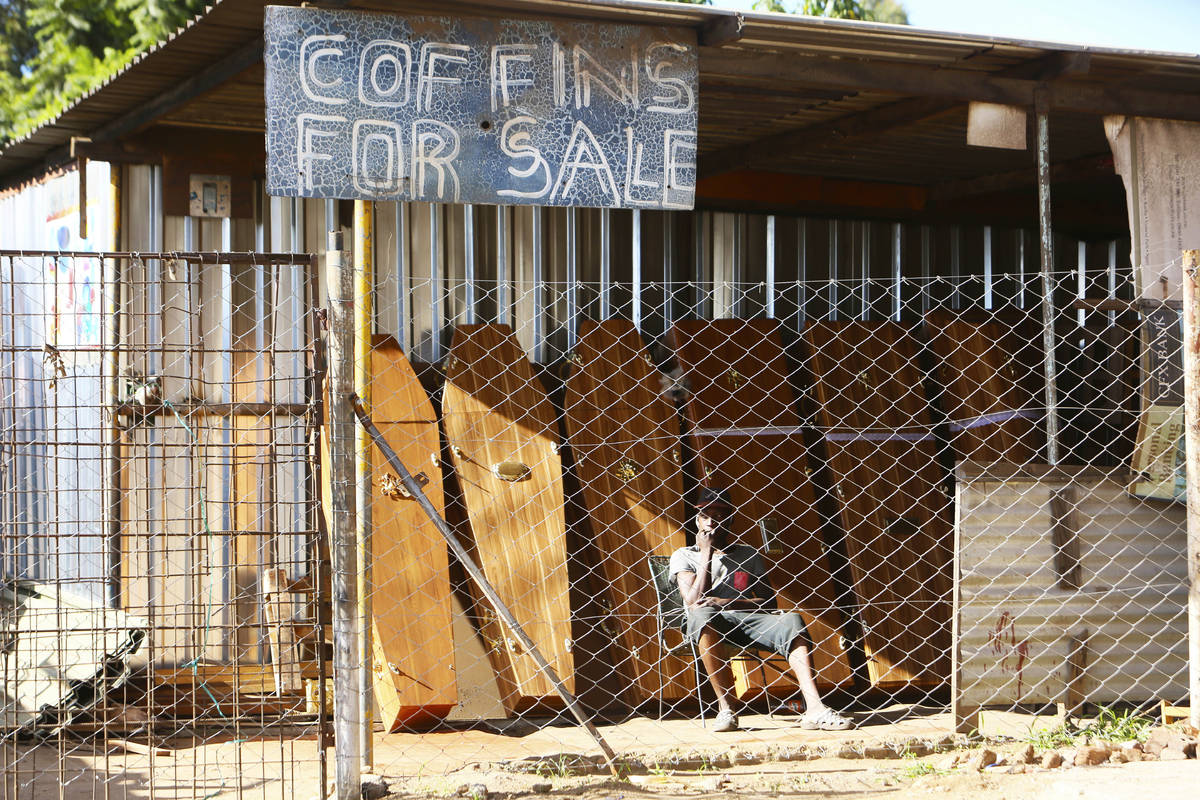 A worker at a coffin making company waits for clients inside the company premises in Harare, Tu ...