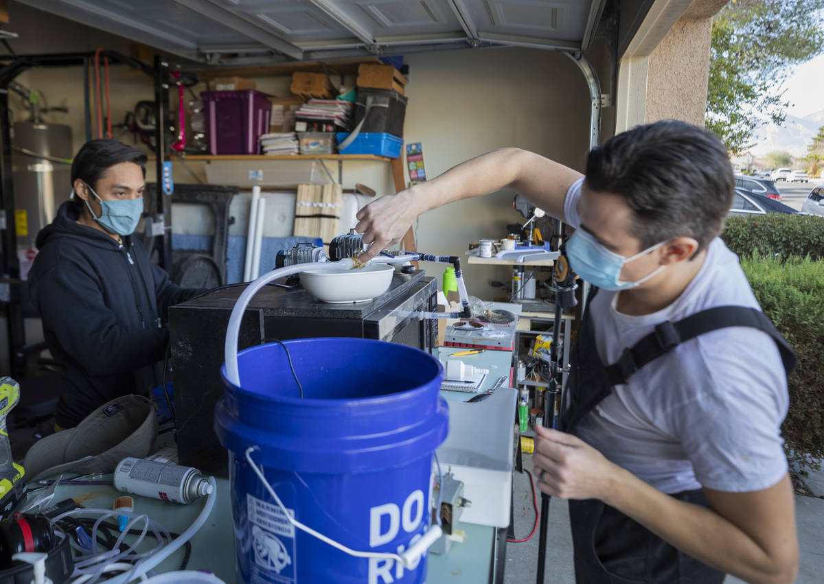 UNLV graduates Jeffrey Topacio, 32, left, and Scott Isler, 33, work on their project, "Mic ...