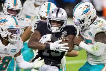 Raiders wide receiver Nelson Agholor (15) is stacked up by Miami Dolphins strong safety Bobby M ...
