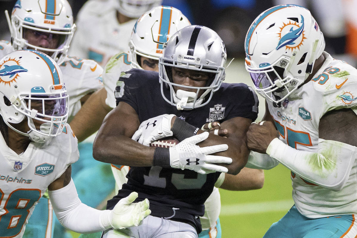 Raiders wide receiver Nelson Agholor (15) is stacked up by Miami Dolphins strong safety Bobby M ...