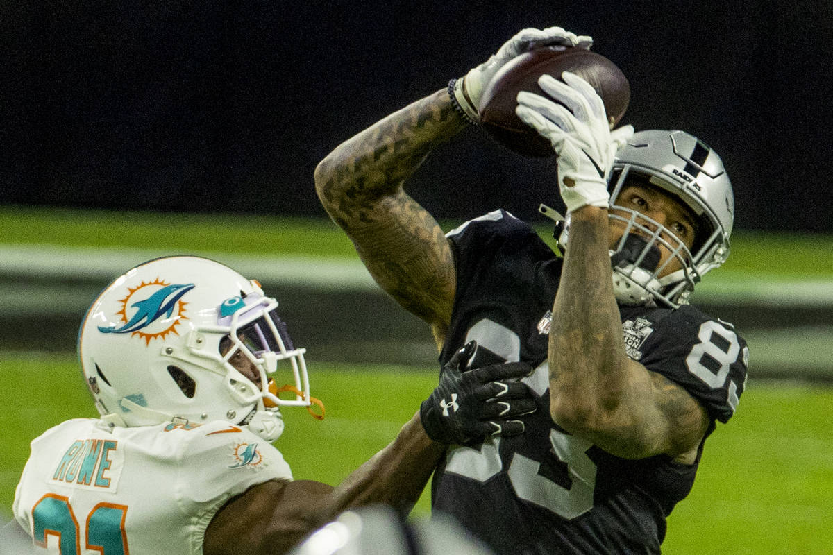 Raiders tight end Darren Waller (83) makes a long reception over Miami Dolphins free safety Eri ...