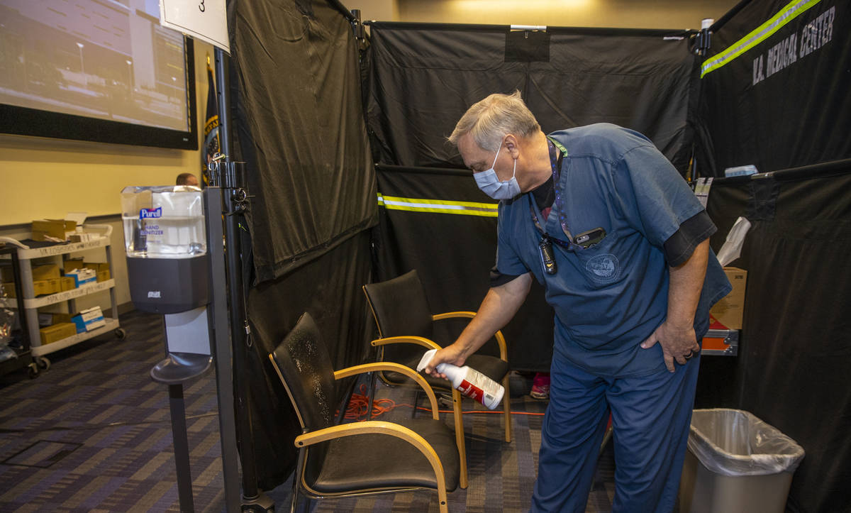 RN Darrel Cowlishaw sanitizes his pod as some of the first veterans locally get a Pfizer COVID- ...