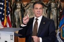 In this Dec. 3, 2020, photo provided by the Office of Gov. Andrew Cuomo, Cuomo holds up samples ...