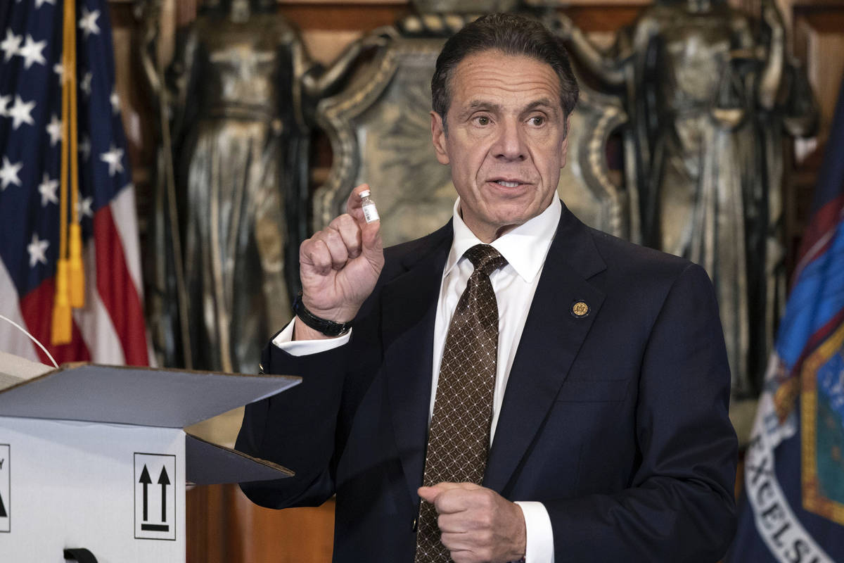 In this Dec. 3, 2020, photo provided by the Office of Gov. Andrew Cuomo, Cuomo holds up samples ...