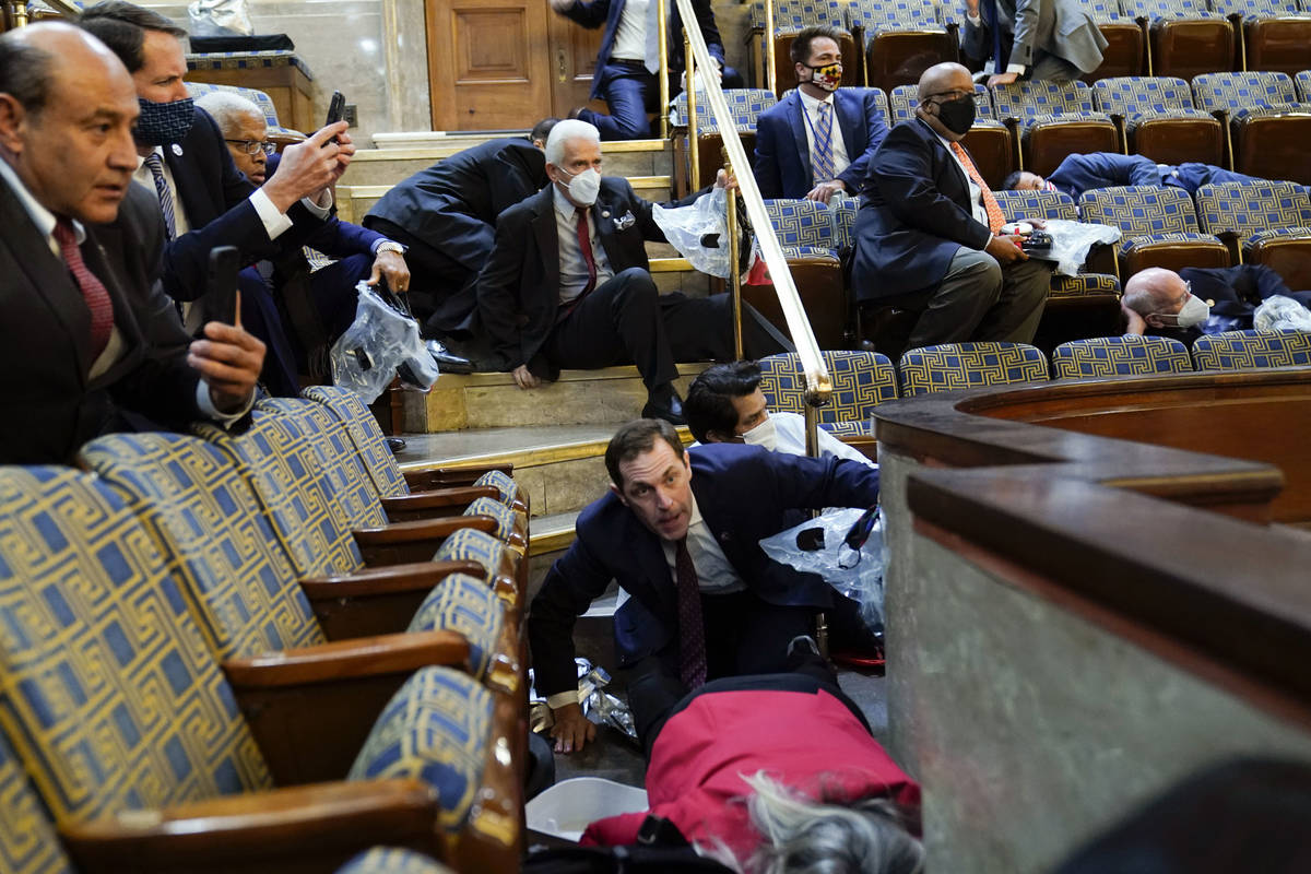 People shelter in the House gallery as protesters try to break into the House Chamber at the U. ...