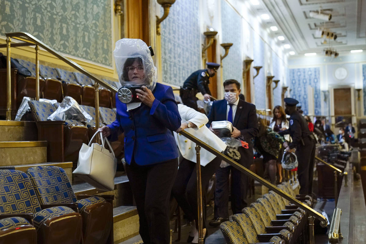 People shelter in the House gallery as protesters try to break into the House Chamber at the U. ...