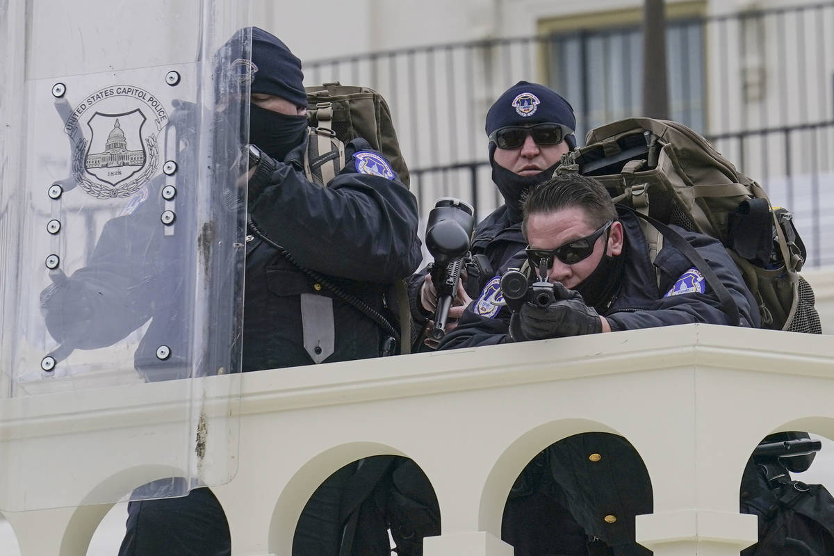 Police keep a watch on demonstrators who tried to break through a police barrier, Wednesday, Ja ...