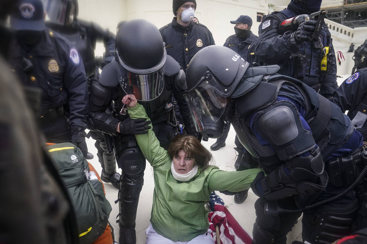 A woman is helped up by police during a rally Wednesday, Jan. 6, 2021, at the Capitol in Washin ...