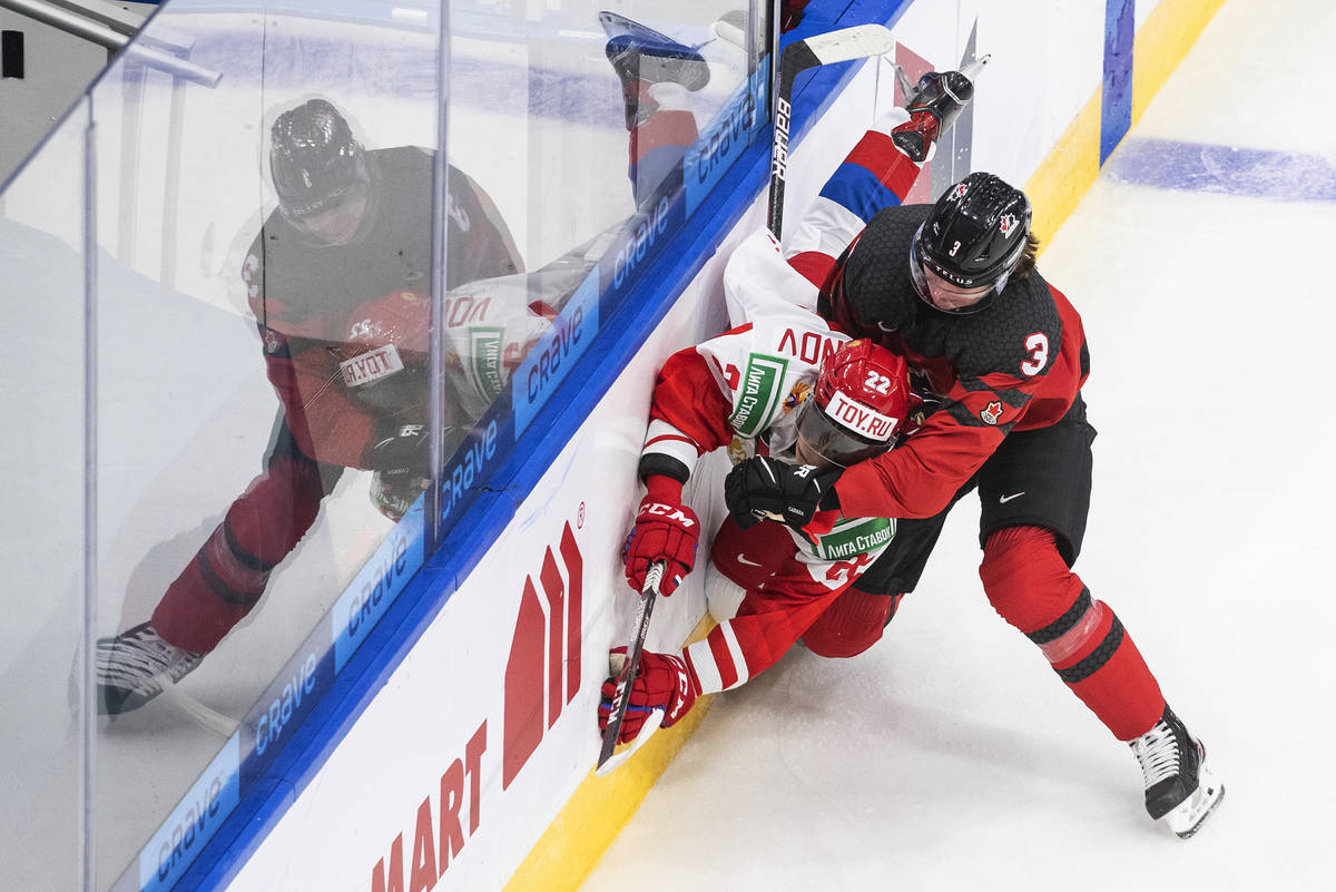 Canada's Kaedan Korczak (3) checks Russia's Marat Khusnutdinov (22) during the first period of ...