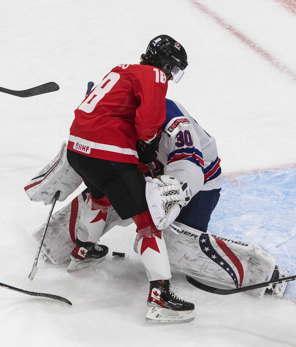 Canada's Peyton Krebs (18) slides against U.S. goalie Spencer Knight (30) during the third peri ...