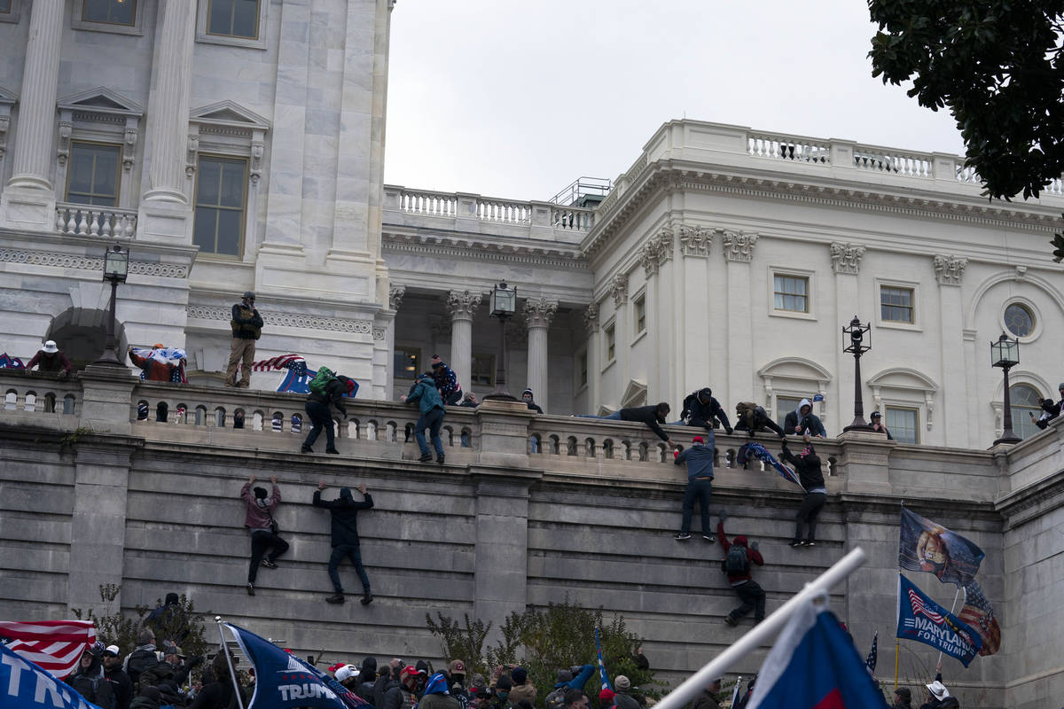 Supporters of President Donald Trump climb the West wall of the the U.S. Capitol on Wednesday, ...