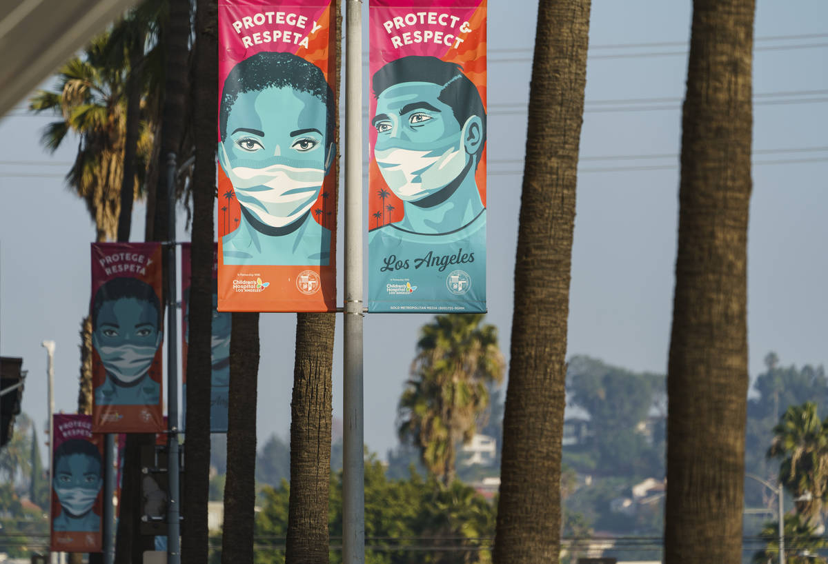 Banners advising people to wear masks against the coronavirus hang along Hollywood Boulevard in ...