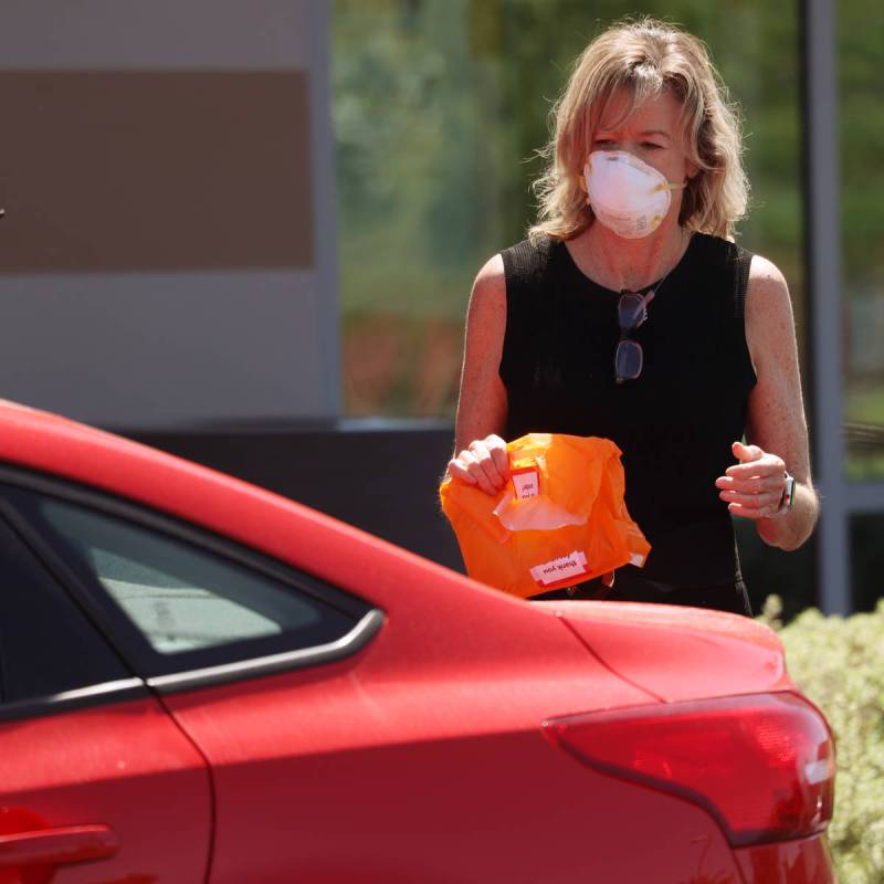 An employee at Ulta Beauty delivers a curbside pickup order at Downtown Summerlin in Las Vegas, ...