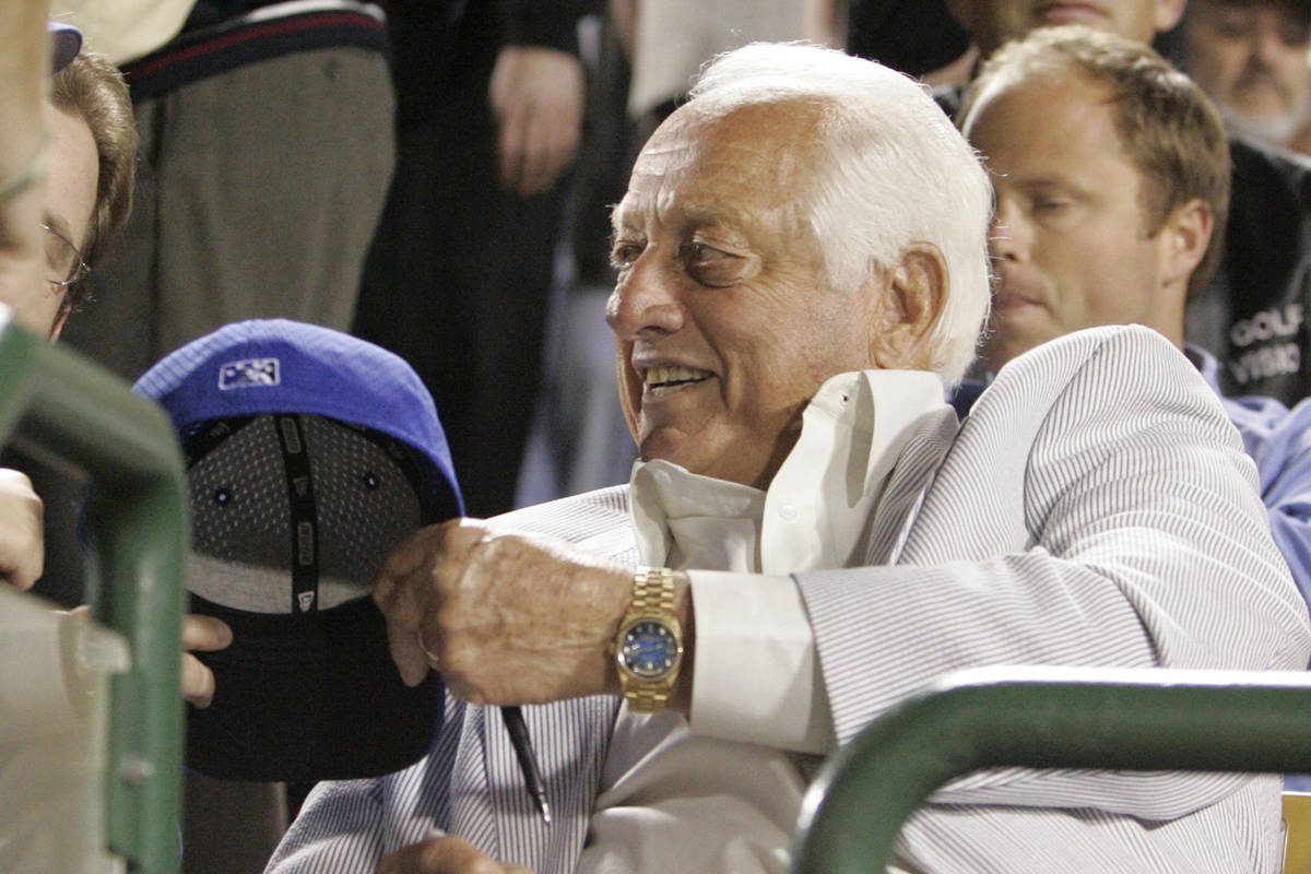 Former Los Angels Dodger coach Tommy Lasorda signs autograph as the Seattle Mariners take on th ...