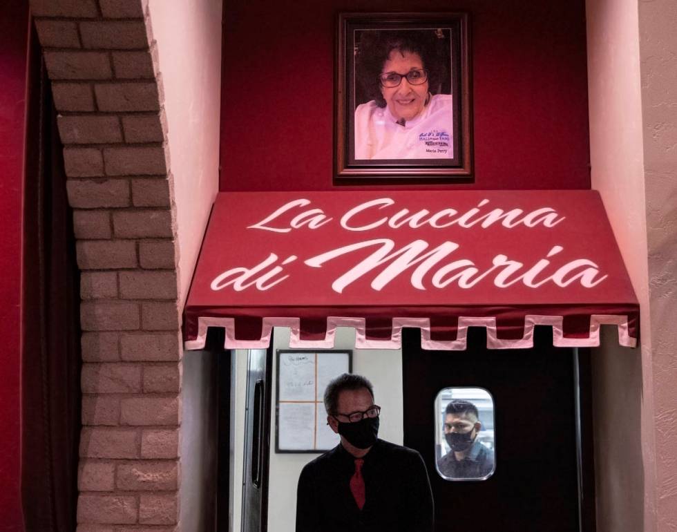 Servers walk out of the kitchen under a large photo of Bootlegger co founder and chef Maria Per ...
