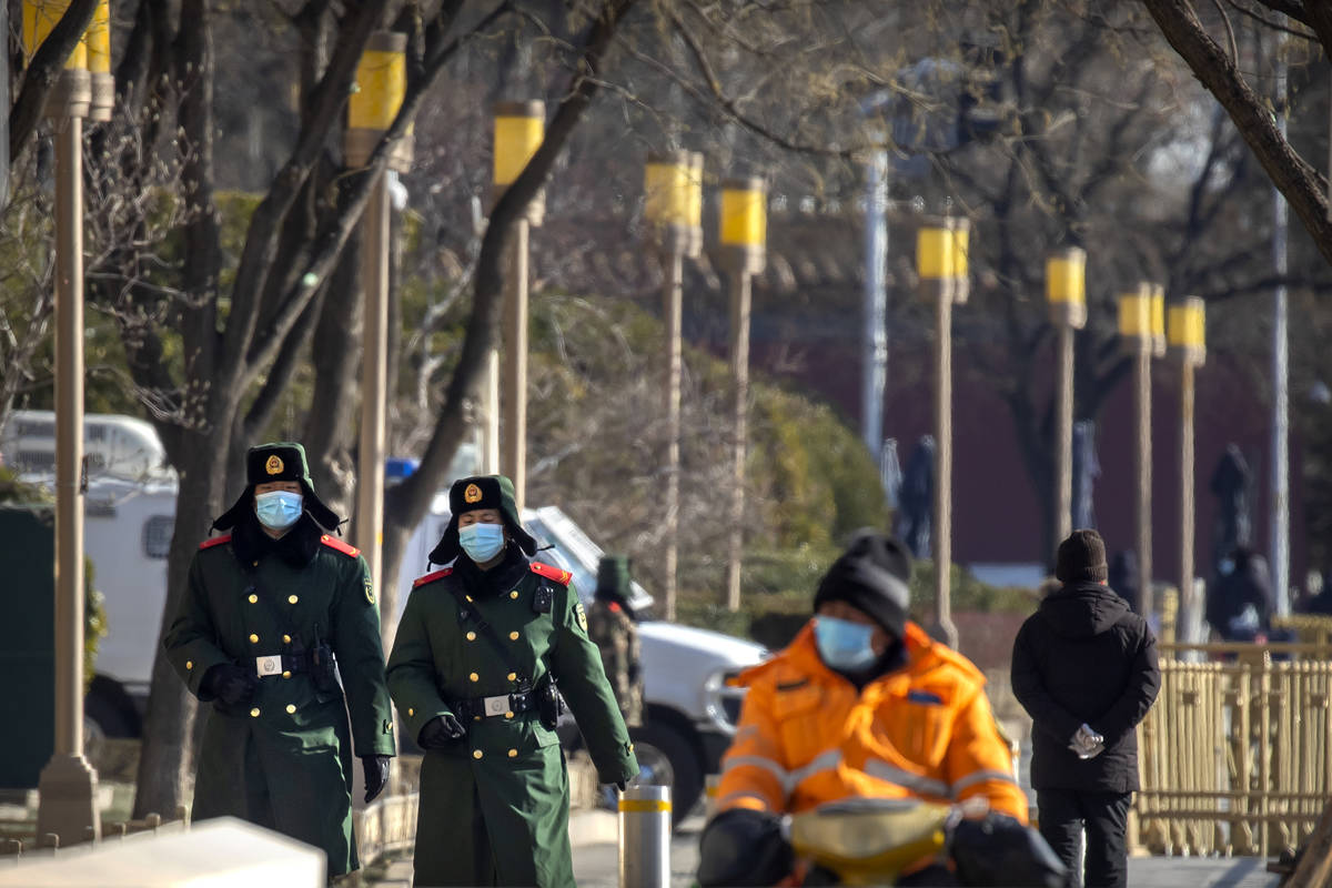 Chinese paramilitary police wearing face masks to protect against the spread of the coronavirus ...