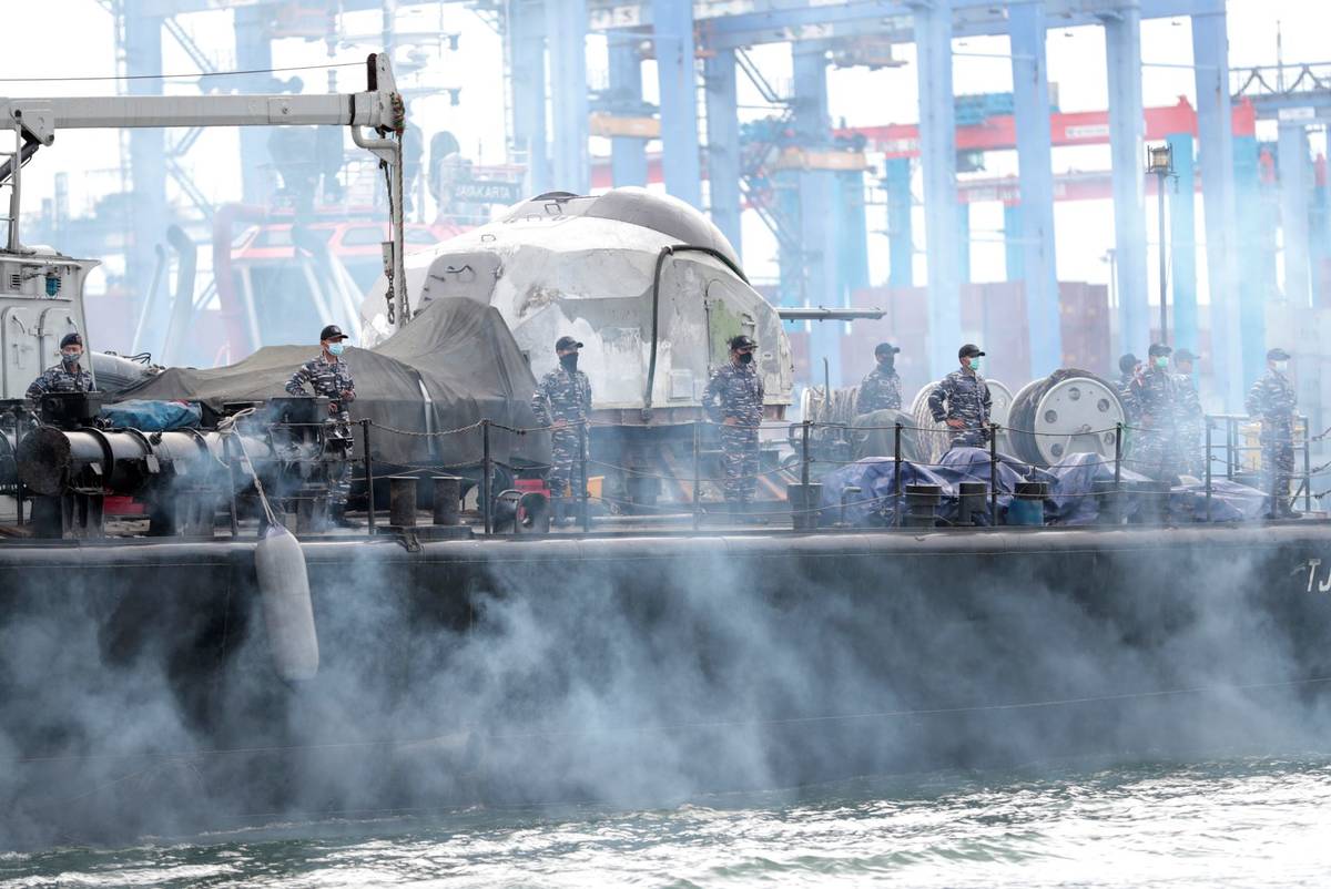Sailors of an Indonesian Navy ship stand on the deck as they depart for a rescue operation for ...