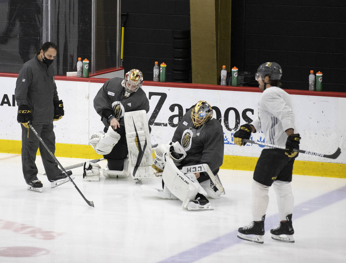 Golden Knights goalie coach Mike Rosario, left, talks with Golden Knights goaltenders Robin Leh ...