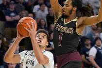 Utah State guard Diogo Brito (24) takes a shot as Saint Katherine's Austin Armstead (1) defends ...