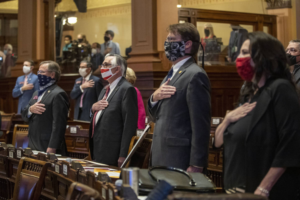 Members of the Georgia House of Representatives stand for the pledge of allegiance during the f ...
