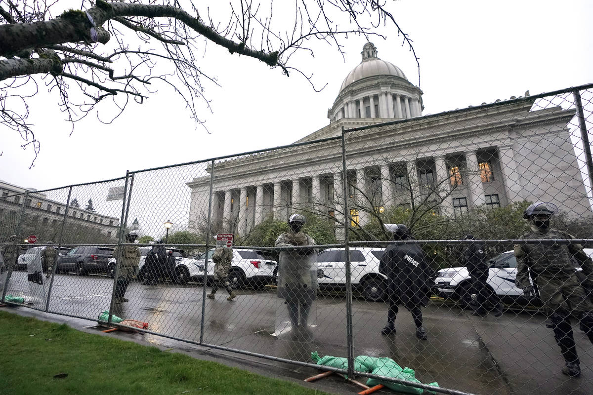 Members of the Washington National Guard stand near a fence surrounding the Capitol in anticipa ...