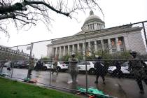 Members of the Washington National Guard stand near a fence surrounding the Capitol in anticipa ...