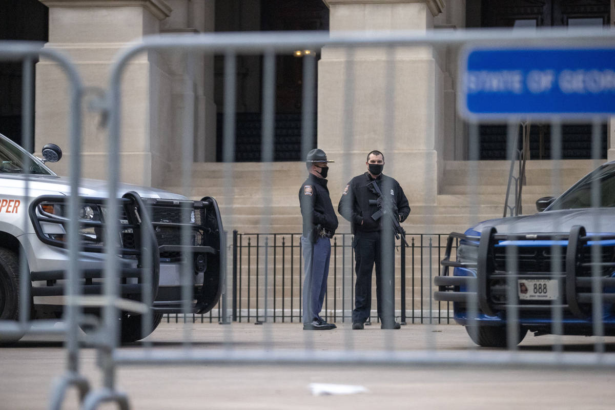 Georgia State Troopers stand guard in front of the Georgia State Capitol building on the first ...