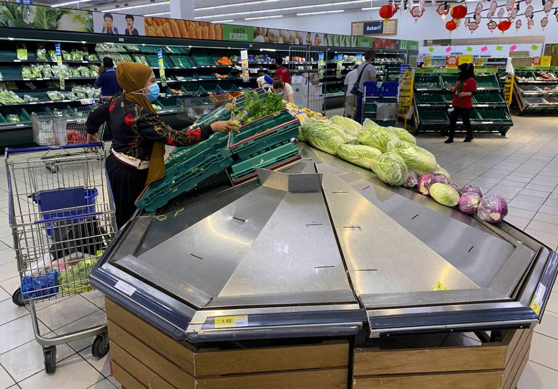 A woman shops for vegetables at a shopping mall in Kuala Lumpur, Malaysia, Tuesday, Jan. 12, 20 ...