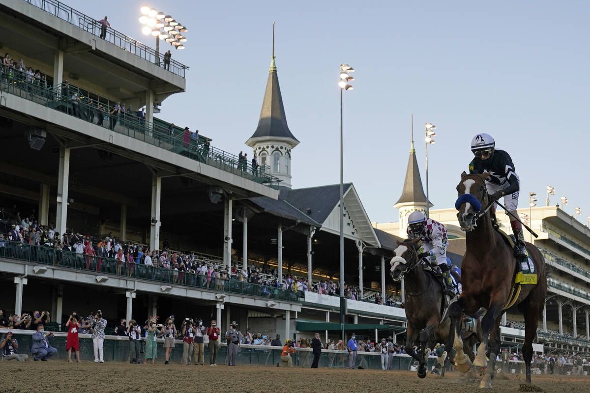 Jockey John Velazquez riding Authentic, right, crosses the finish line to win the 146th running ...