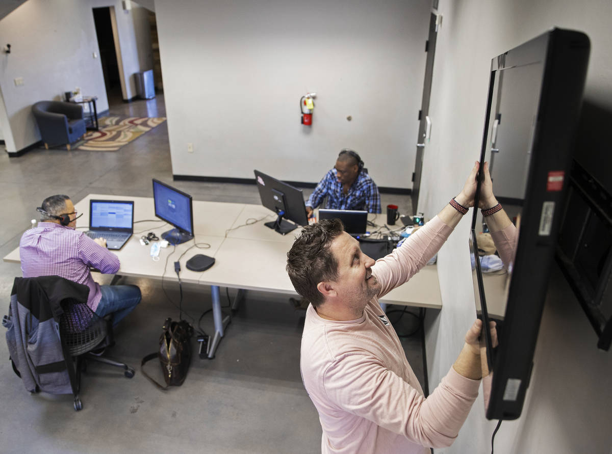 Kenny Eliason, co-owner of Work in Progress, removes a television from the wall during the busi ...