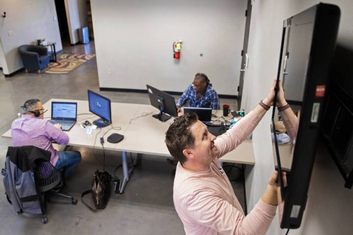 Kenny Eliason, co-owner of Work in Progress, removes a television from the wall during the busi ...