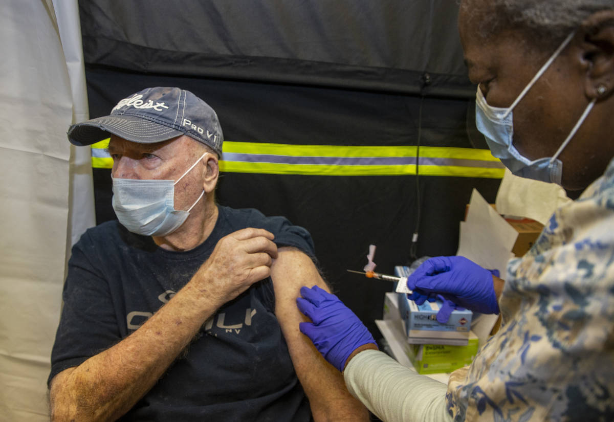 Veteran Jack Daughtrey, left, receives a shot from RN Francine Jones-Toliver as some of the fir ...