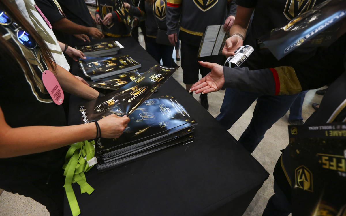 Golden Knights fans pickup posters before the start of Game 1 of an NHL hockey first round play ...
