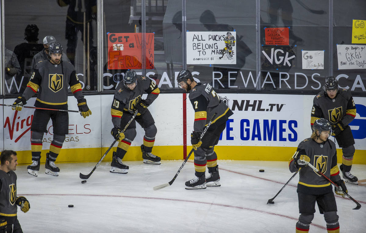 Golden Knights players warm up about handwritten signs from fans during the warm ups of an NHL ...