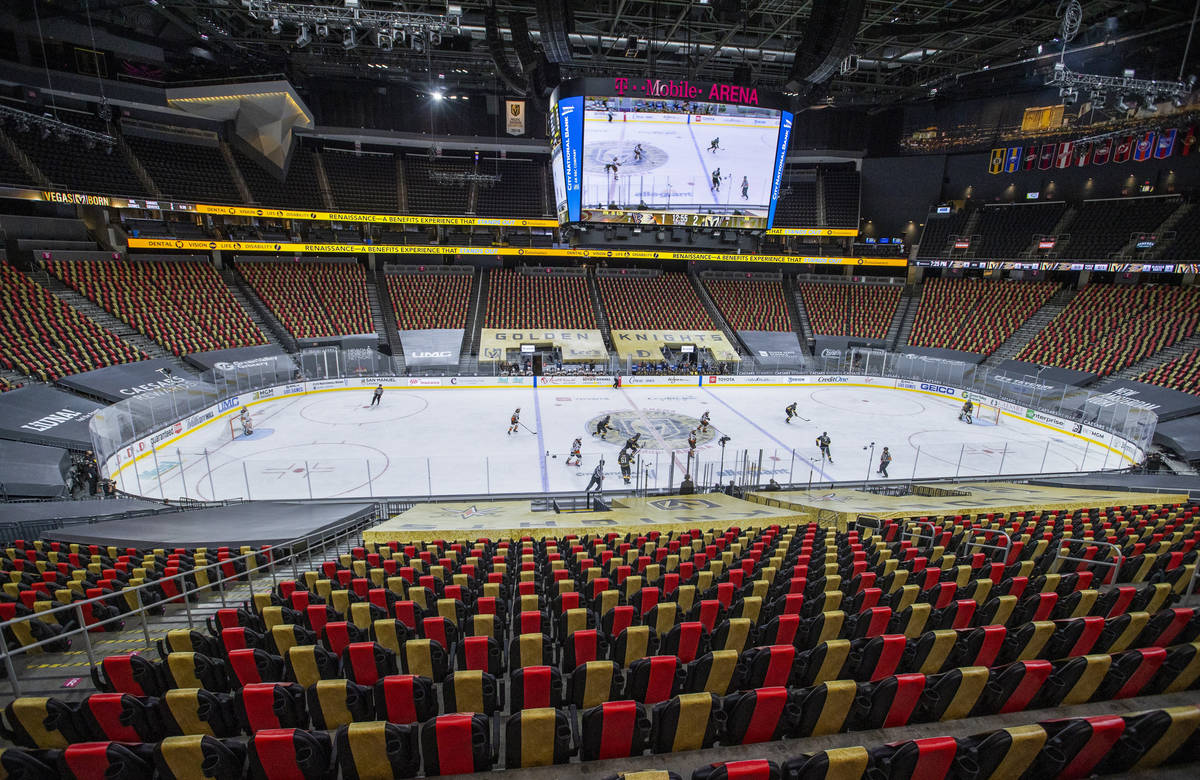 Golden Knights and Anaheim Ducks players battle to an empty arena during the first period of an ...