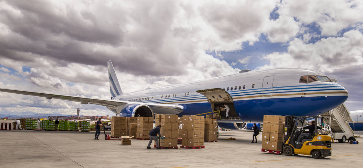 Transport workers stack some of the 1 million surgical masks arriving from Guangzhou, China, at ...