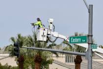 A city of Henderson worker installs adaptive traffic signal equipment as part of the a pilot pr ...