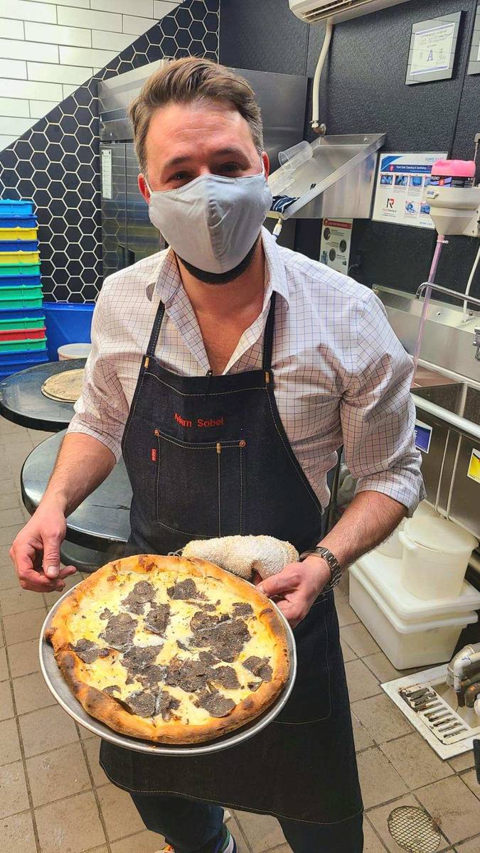 Mina Group Chef Adam Sobel shows off a pizza for auction at Sand Dollar Lounge on Sunday, Jan. ...