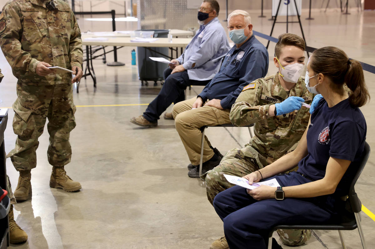 Jasmine Ghazinour, a captain with the Clark County Fire Department, receives a COVID-19 vaccina ...