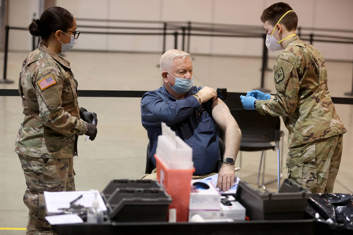 Dennis West, of Nevada Task Force One Urban Search and Rescue, receives a COVID-19 vaccination ...