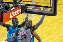 UNLV Rebels forward Cheikh Mbacke Diong (34) battles about the glass with New Mexico Lobos guar ...