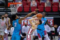 UNLV Rebels guard Caleb Grill (3) leans back to get off a basket between New Mexico Lobos guard ...