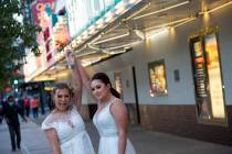 Newlyweds Brittnee Austin, left, and Kirby Kraeymer-Austin pose for their wedding photographer, ...