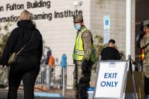 Army National Guard specialist Carlos Mota, middle, directs people to the COVID-19 testing area ...