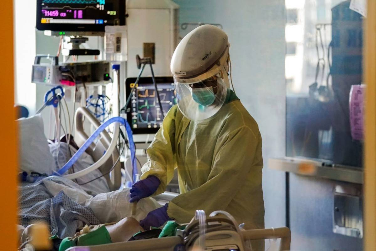 A healthcare worker tends to a COVID-19 patient in the intensive care unit at Santa Clara Valle ...