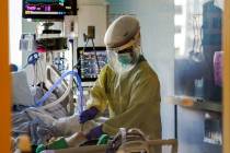 A healthcare worker tends to a COVID-19 patient in the intensive care unit at Santa Clara Valle ...