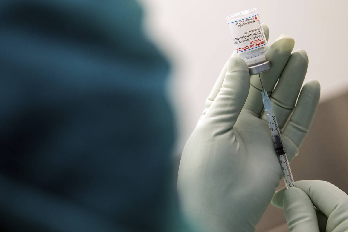 A member of staff at the university hospital prepares the Moderna vaccine against COVID-19 in D ...