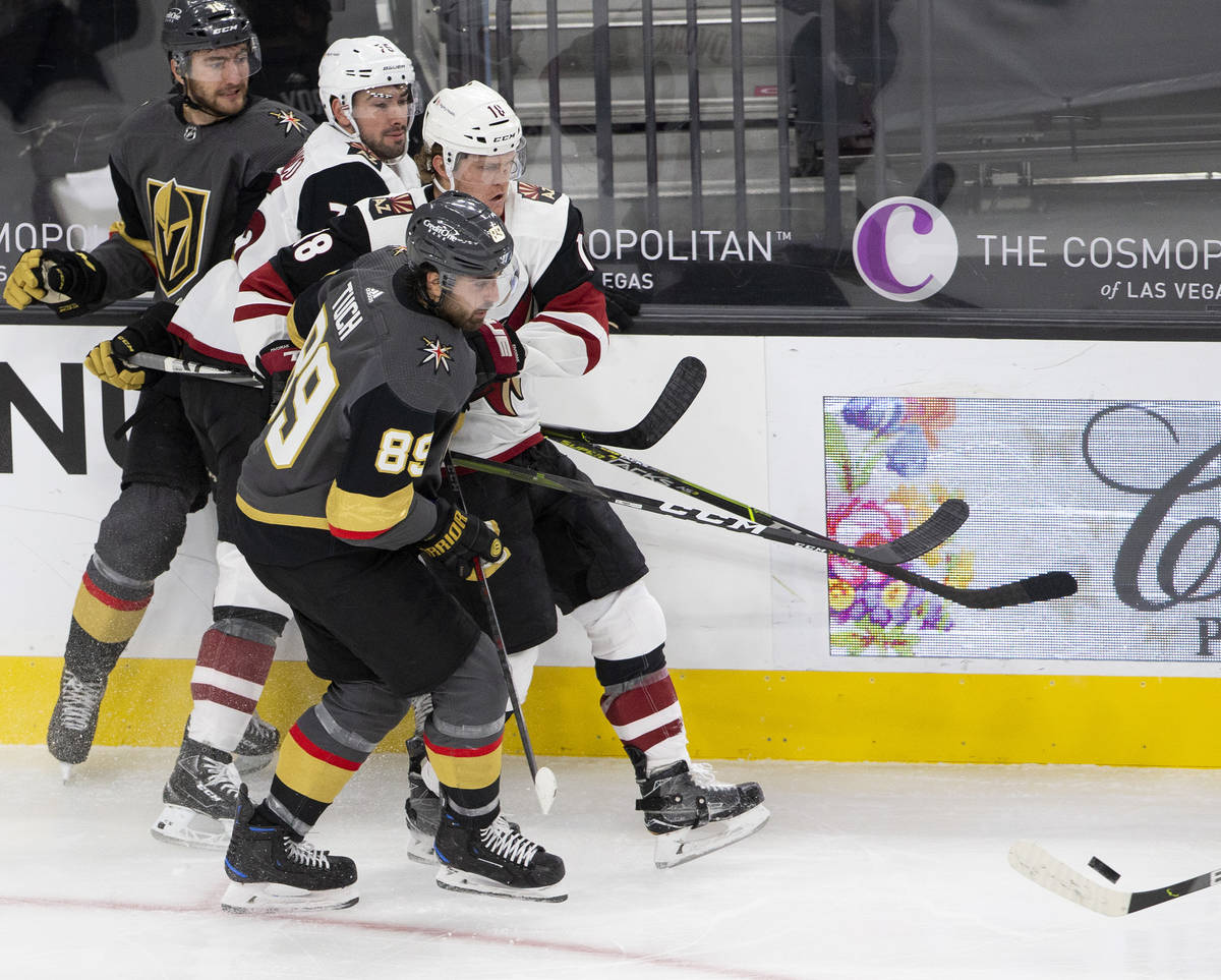 Golden Knights' right wing Alex Tuch (89) and center Nicolas Roy (10) surround Arizona Coyotes' ...