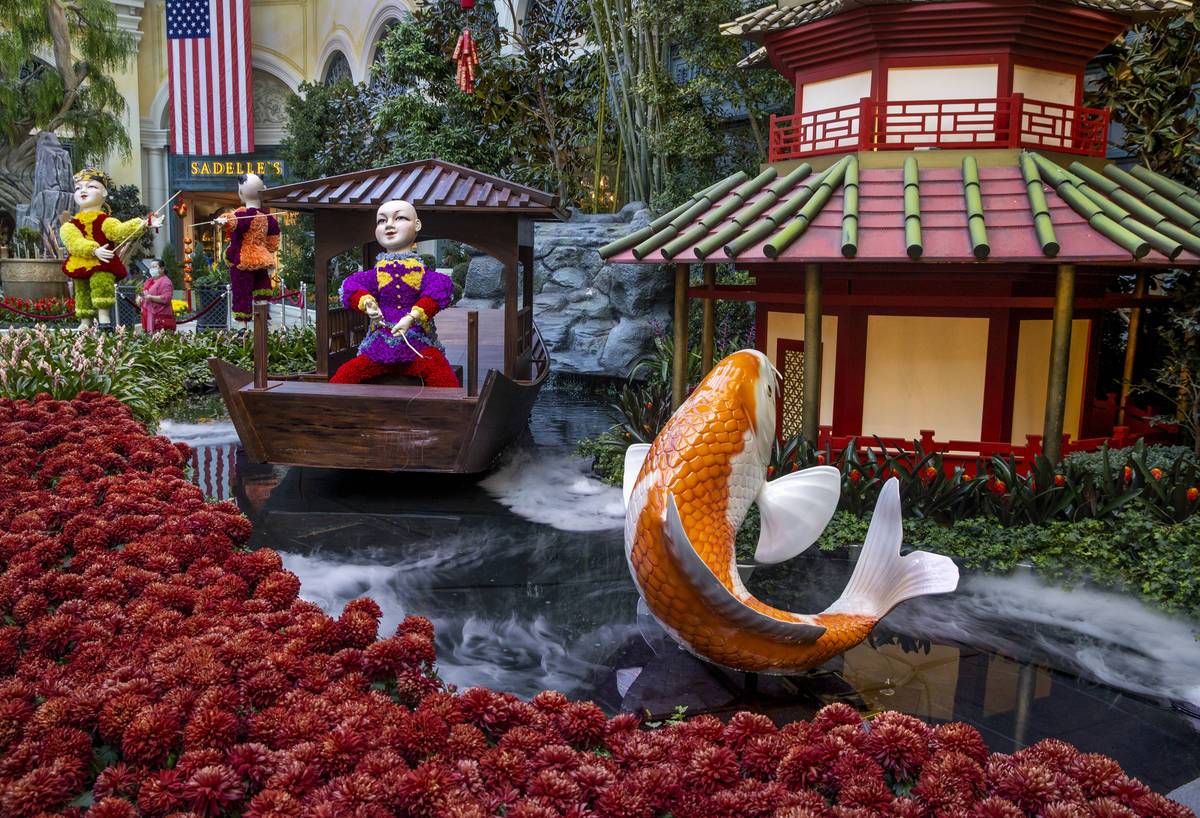 Smoke rises from the pond about a koi and flower-covered fishermen as the Bellagio Conservatory ...